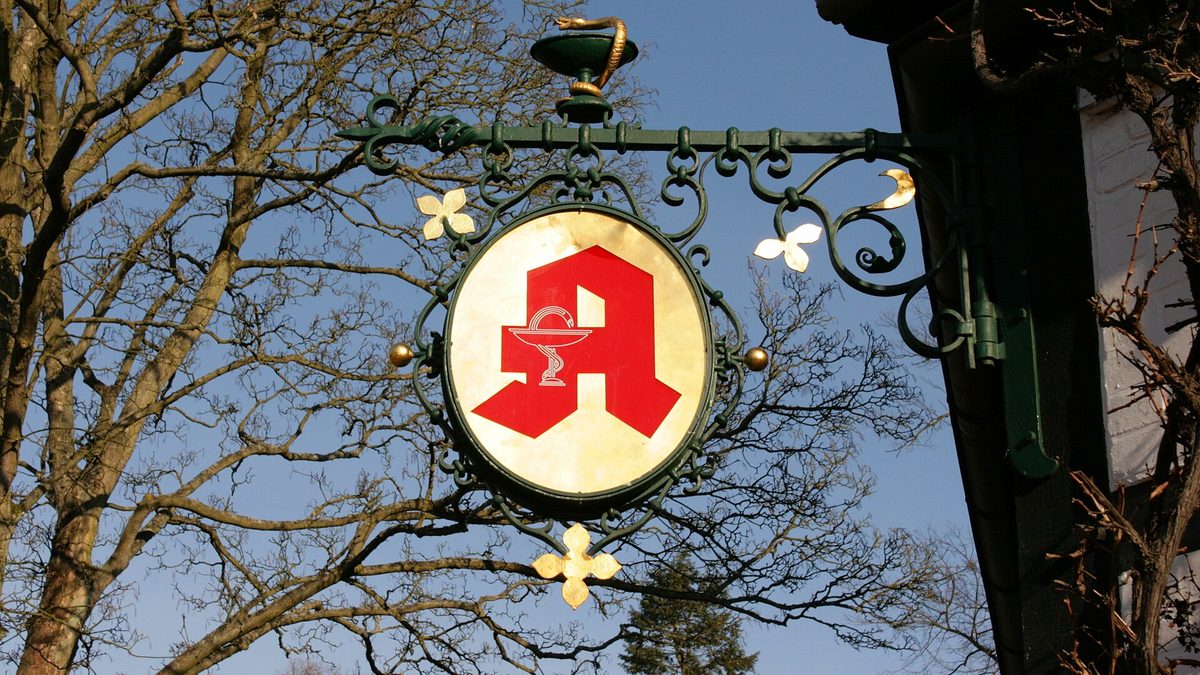 Rotes Apotheken-A auf einem schmiedeeisernen Ausleger vor blauem Himmel