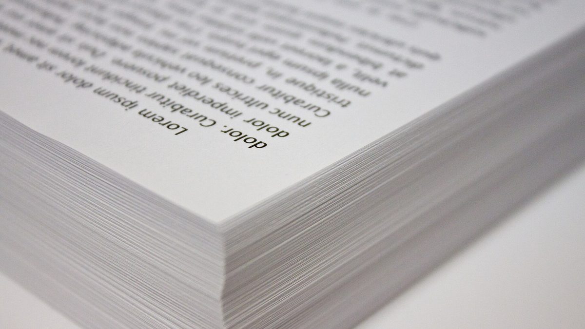 Nahaufnahme eines hohen Stapels frisch bedruckter weißer Papierblätter