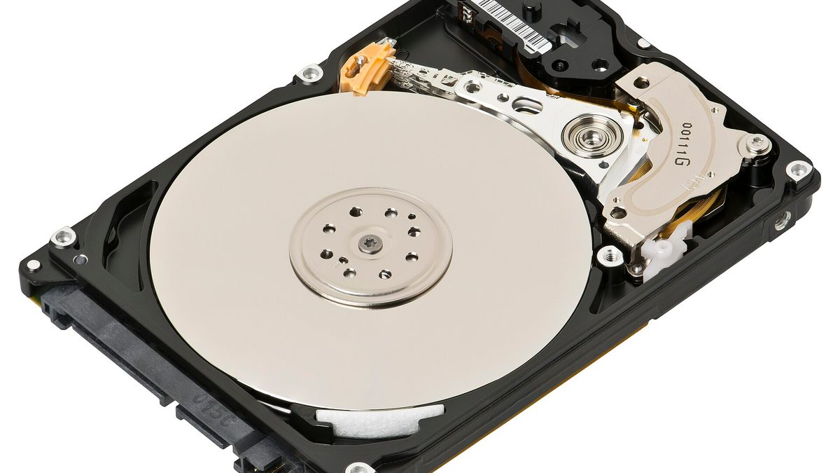 Geöffnete Laptop-Festplatte mit Magnetscheibe und Schreib-Lese-Kopf auf weißem Hintergrund