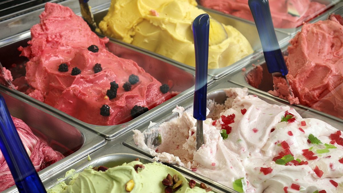 Bunte Eissorten mit Beeren und Pistazien in der Theke einer Eisdiele