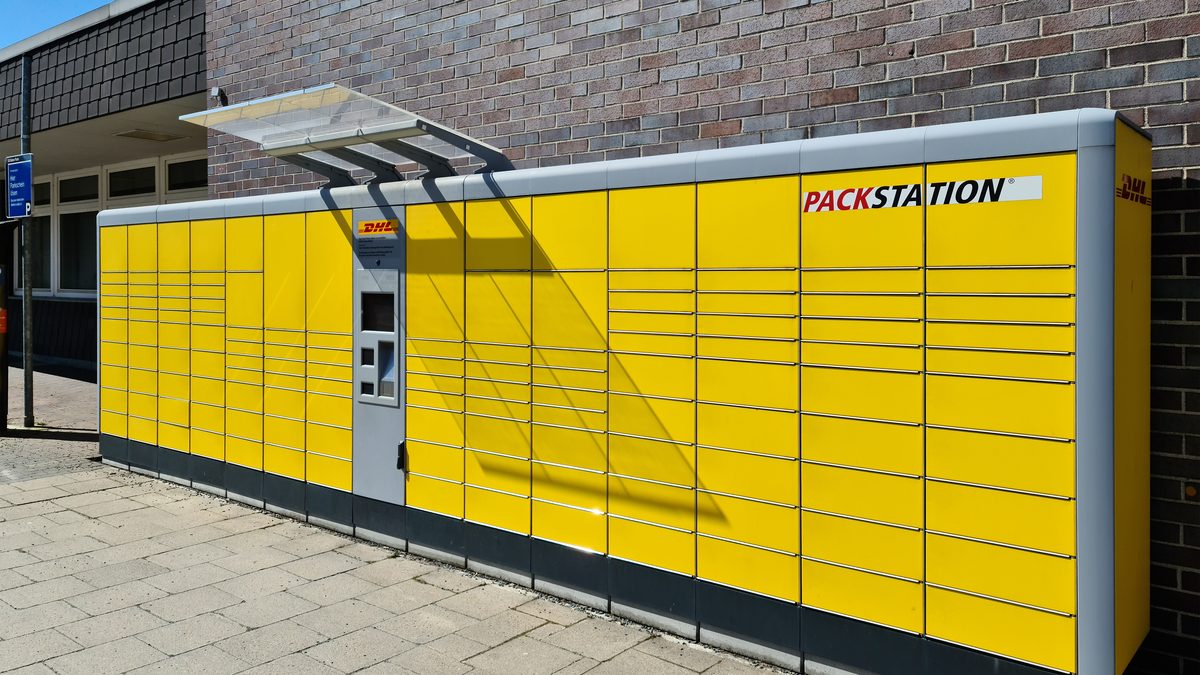 Gelbe DHL-Packstation an einer Hauswand