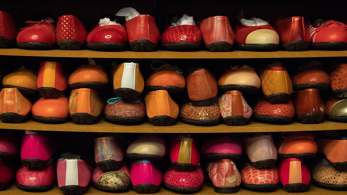 Regal mit bunten Ballerinas in Rot-, Orange- und Pinktönen in einem Schuhgeschäft