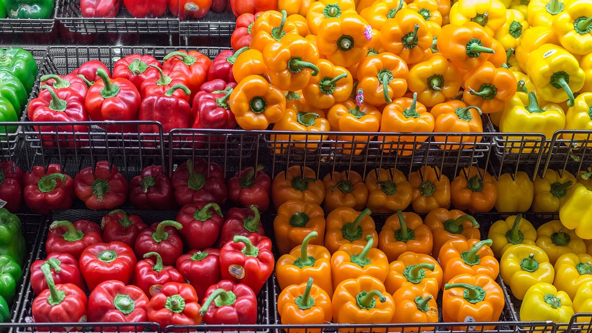 Nach Farben sortierte Paprika in Drahtkörben in der Gemüseabteilung eines Supermarkts