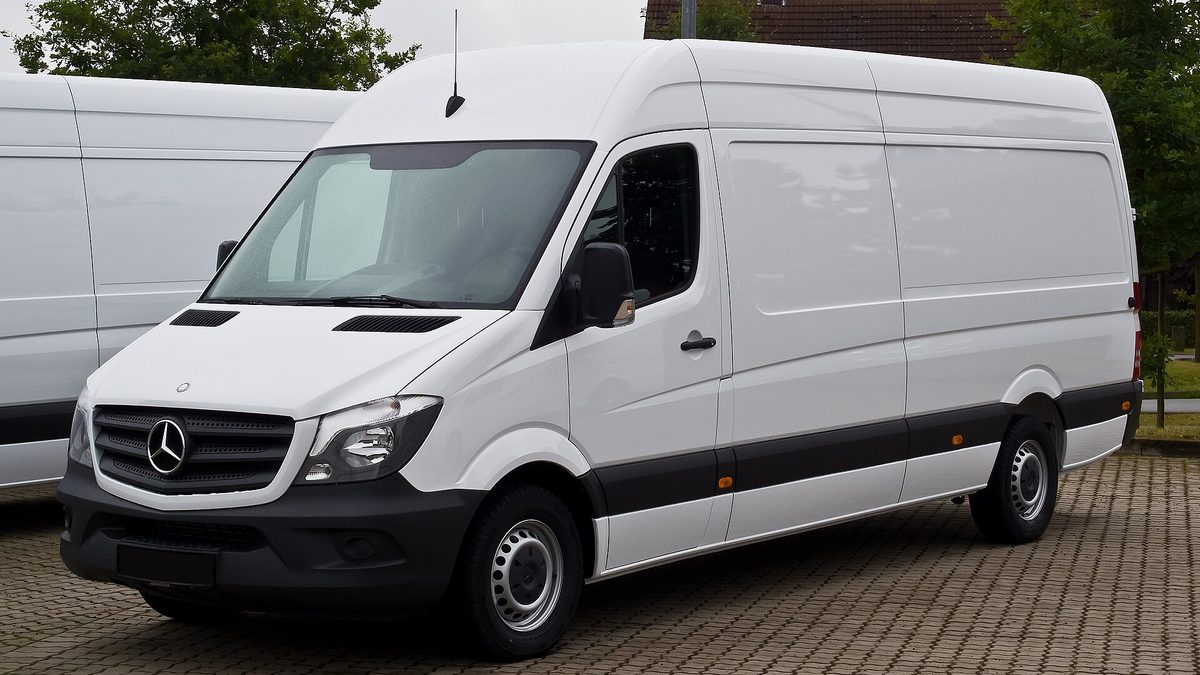 Weißer Kastenwagen-Transporter mit Hochdach auf einem gepflasterten Parkplatz