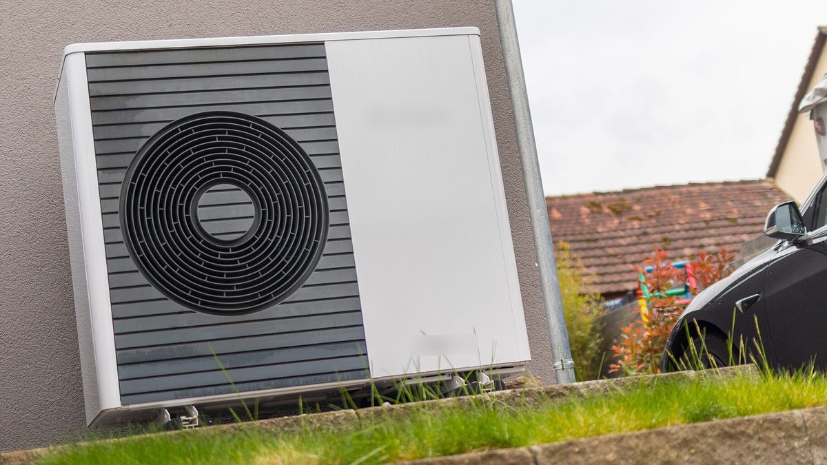 Außeneinheit einer Luft-Wasser-Wärmepumpe an der Hauswand eines Einfamilienhauses